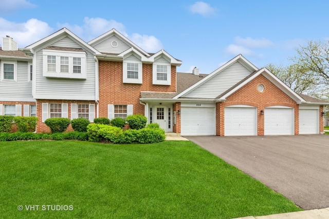 view of front facade with brick siding, asphalt driveway, a front yard, and an attached garage
