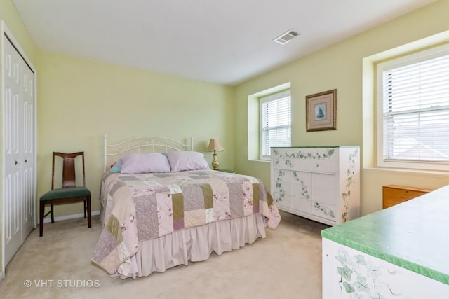 bedroom featuring light colored carpet and a closet