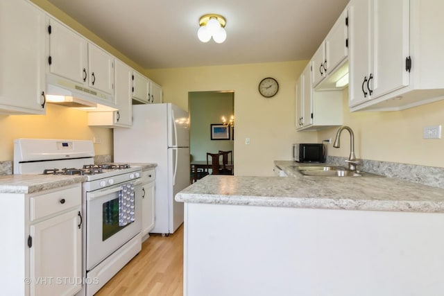 kitchen with white appliances, under cabinet range hood, a sink, and white cabinetry