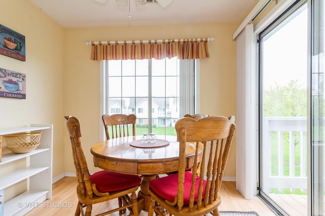 dining room featuring light wood-type flooring, ceiling fan, and baseboards