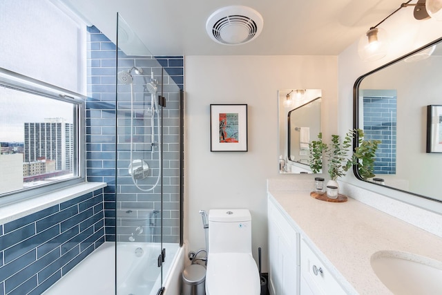 full bath featuring toilet, vanity, and shower / tub combination