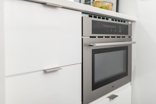 kitchen view of stainless steel oven and white fridge