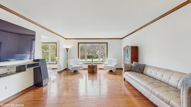 living room with crown molding, baseboards, and light wood-style flooring