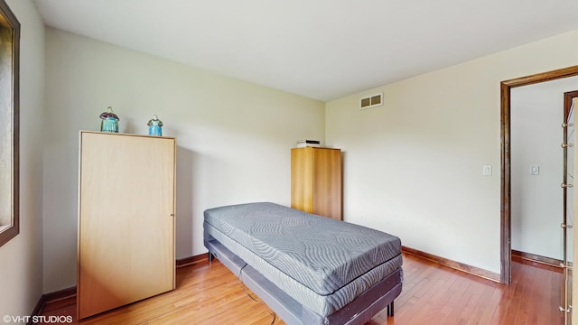 bedroom featuring light wood-style floors, baseboards, and visible vents