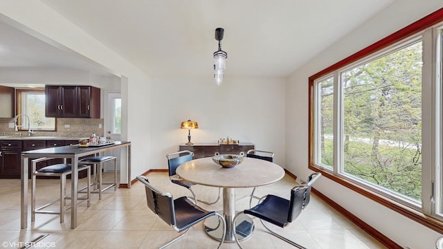 dining area with baseboards, light tile patterned floors, and a wealth of natural light