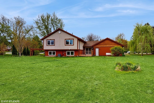 rear view of house featuring stucco siding and a yard