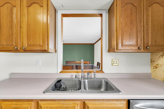 kitchen featuring a sink, light countertops, brown cabinetry, and dishwasher