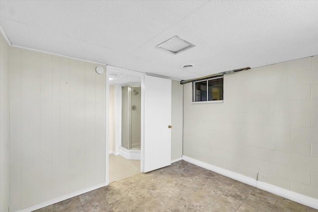 finished basement with a textured ceiling and baseboards