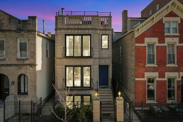 townhome / multi-family property featuring a fenced front yard and a gate