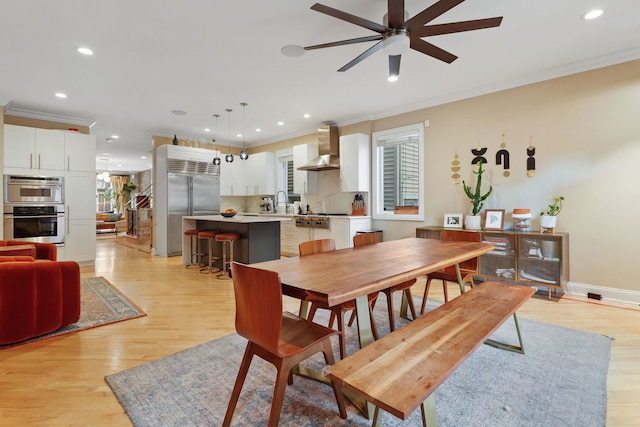 dining space with crown molding, ceiling fan, recessed lighting, light wood-style floors, and baseboards