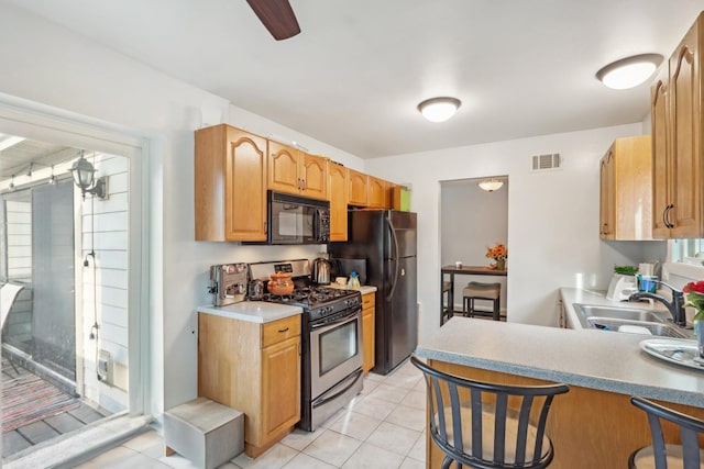 810 E Kings Row Unit 6, Palatine, IL 60074 - kitchen featuring light tile patterned flooring, a sink, a breakfast bar area, visible vents, and black appliances