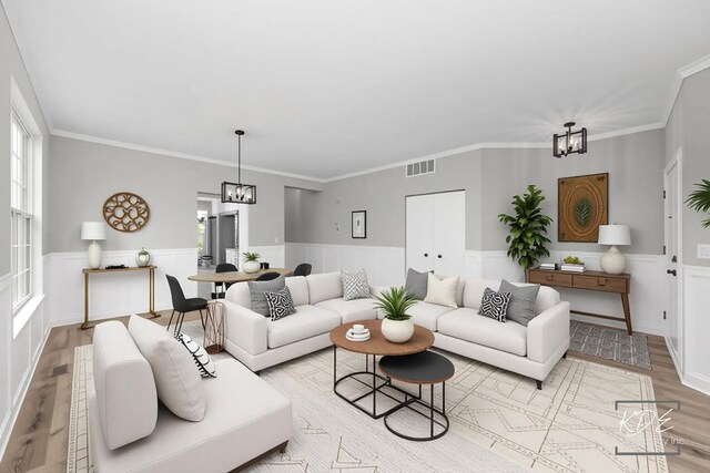 living area featuring a chandelier, visible vents, wainscoting, and light wood-type flooring