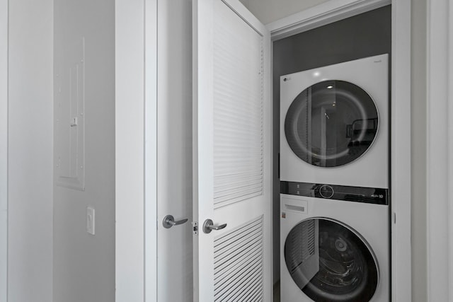 washroom with stacked washing maching and dryer and laundry area