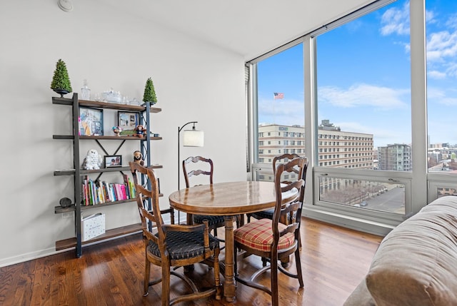 dining space featuring a view of city and wood finished floors