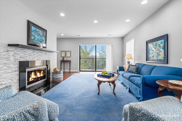 living area featuring recessed lighting, wood finished floors, a wealth of natural light, and a fireplace
