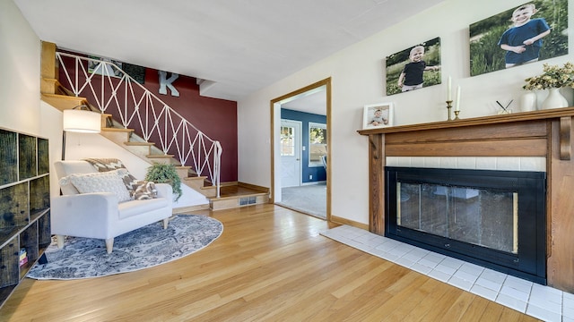 1008 Mary Ave, Dixon, IL 61021 - living room featuring wood finished floors, stairs, a tile fireplace, and baseboards