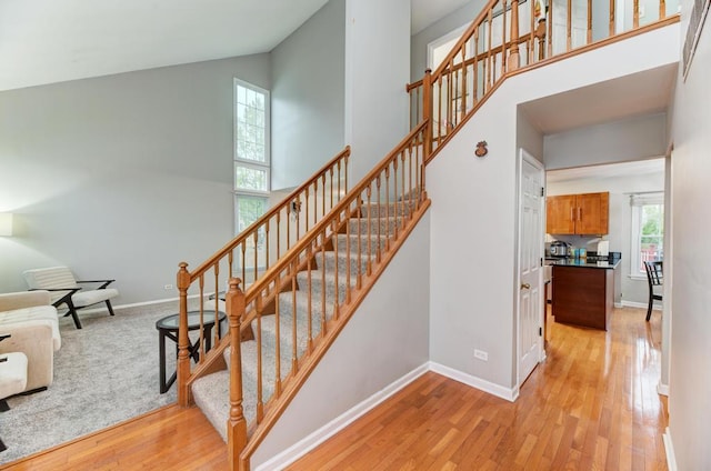 3615 Fairfax Ct E, Aurora, IL 60504 - stairway featuring high vaulted ceiling, wood finished floors, and baseboards