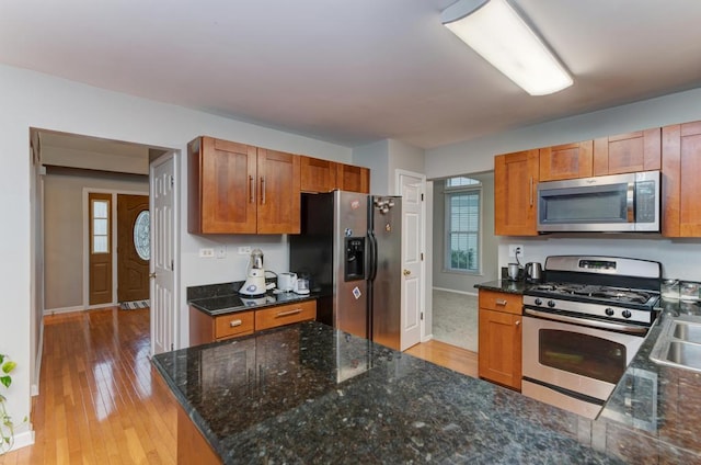 3615 Fairfax Ct E, Aurora, IL 60504 - kitchen featuring appliances with stainless steel finishes, light wood-style flooring, brown cabinets, baseboards, and dark stone counters