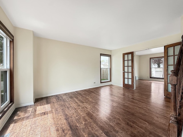 unfurnished room with baseboards and wood finished floors