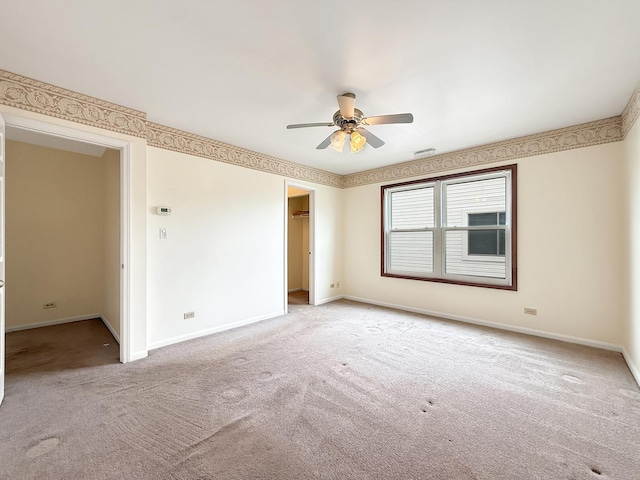 unfurnished bedroom with ceiling fan, baseboards, a closet, a spacious closet, and carpet flooring