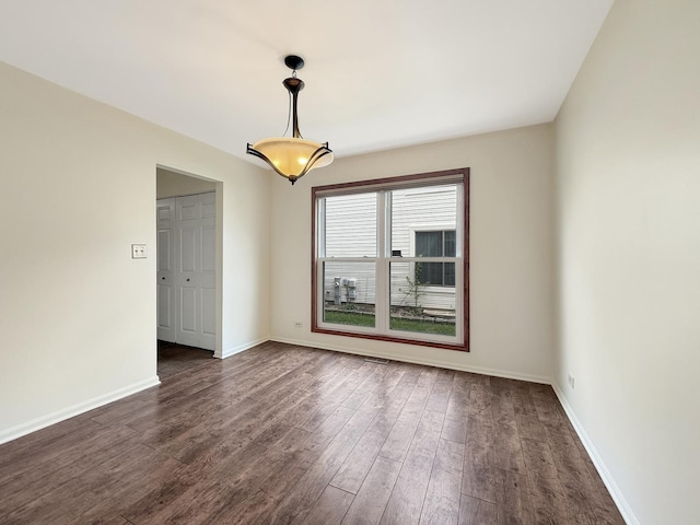 unfurnished room featuring dark wood-style flooring and baseboards