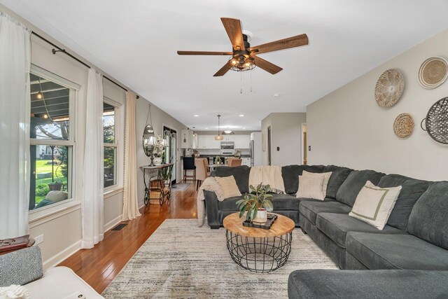 living area with visible vents, dark wood finished floors, ceiling fan, and baseboards