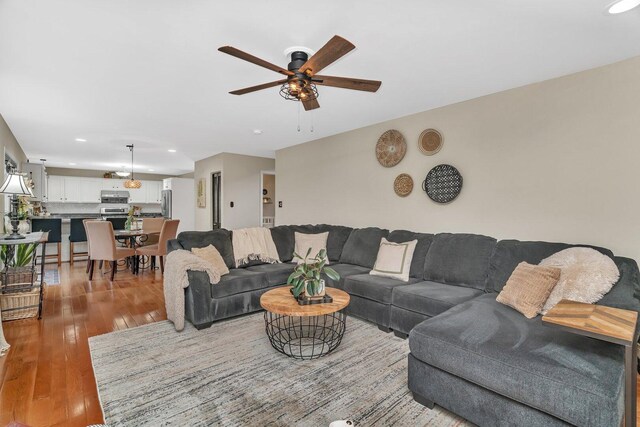 living room featuring light wood-style floors, ceiling fan, and recessed lighting