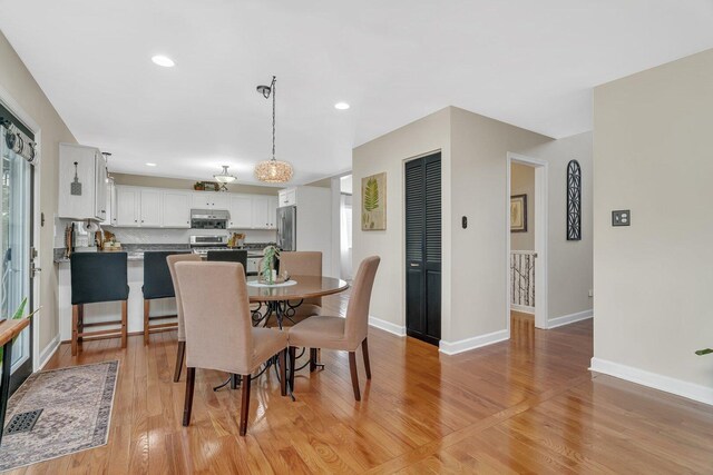 dining room featuring recessed lighting, baseboards, visible vents, and light wood-style flooring