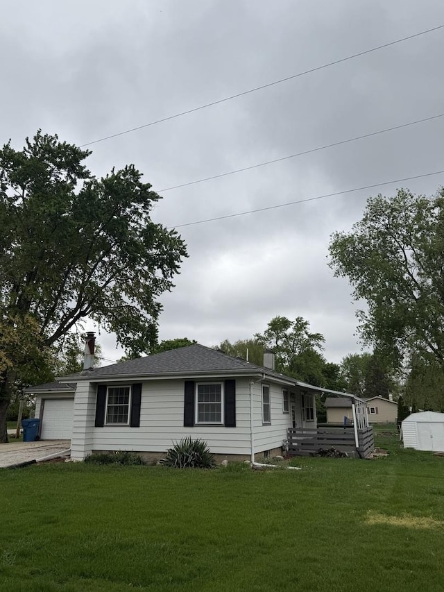 view of front of house featuring a chimney, driveway, a shed, and a front yard