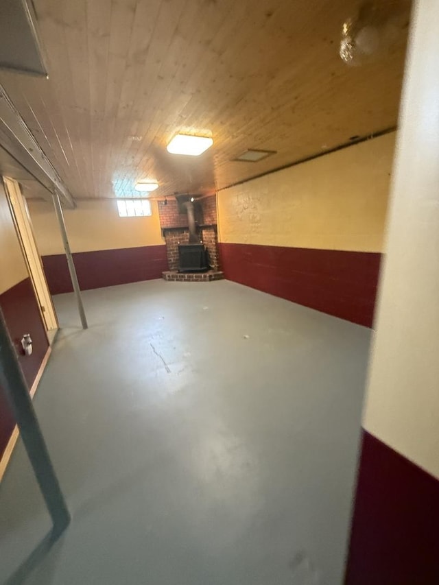basement with wooden ceiling and a wood stove