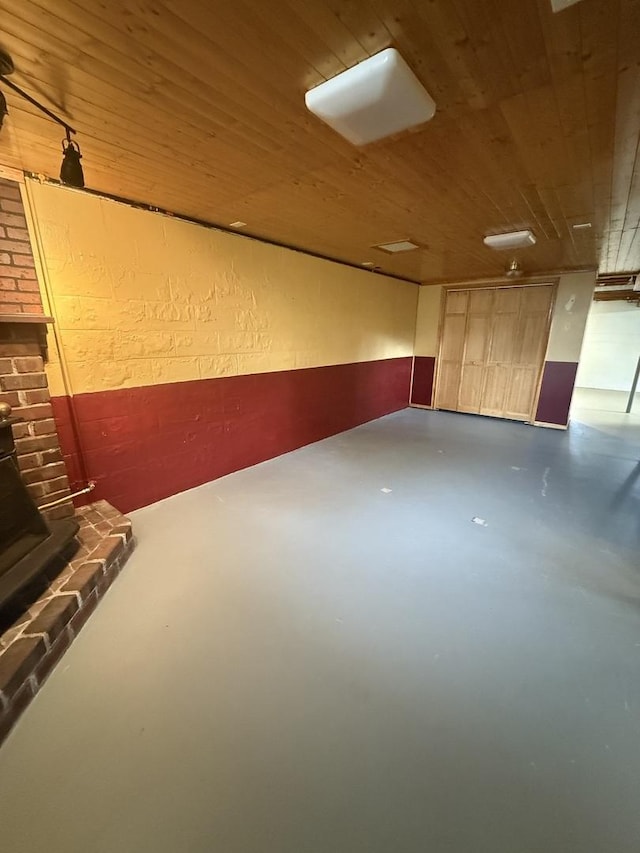 below grade area with wood ceiling and a textured wall