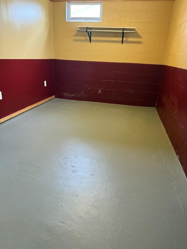 empty room with finished concrete flooring and concrete block wall