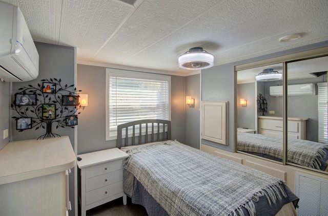 bedroom with a wall unit AC, a closet, and ornamental molding