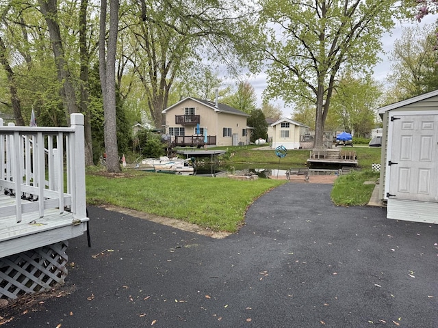view of green lawn with a wooden deck