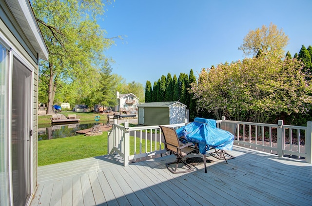 deck featuring a shed, a yard, an outbuilding, and outdoor dining space