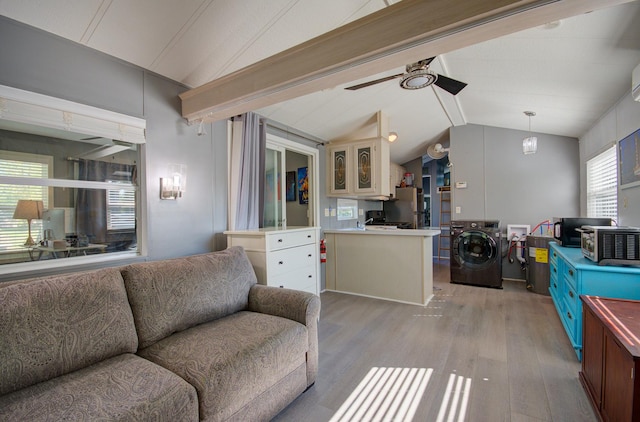 living room featuring washer / dryer, vaulted ceiling, light wood finished floors, and ceiling fan