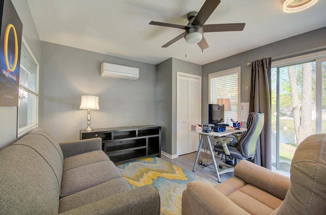 home office with a wall mounted AC, a ceiling fan, wood finished floors, and baseboards