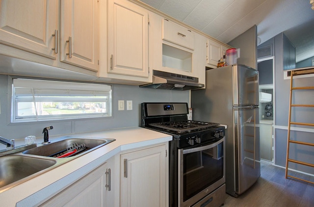 kitchen featuring under cabinet range hood, stainless steel appliances, a sink, light countertops, and dark wood-type flooring
