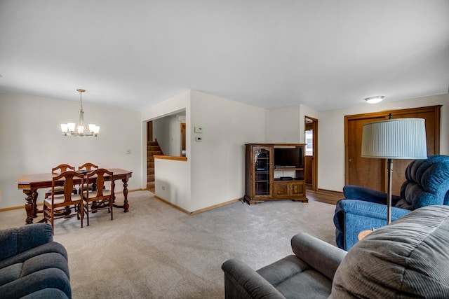 living area with baseboards, carpet floors, a notable chandelier, and stairway