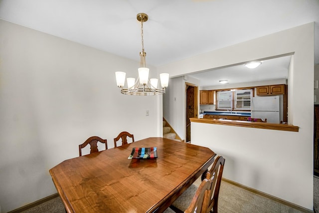 dining area featuring an inviting chandelier, baseboards, stairway, and light colored carpet