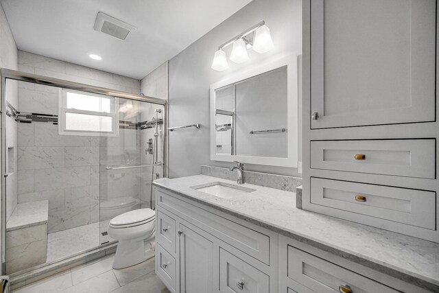 full bathroom with vanity, a stall shower, visible vents, and toilet