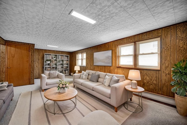 living room featuring wood walls, built in shelves, and carpet