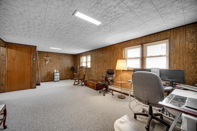 carpeted office space with wooden walls and baseboard heating