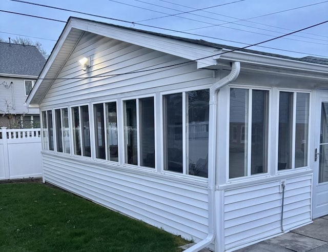 sunroom / solarium featuring a ceiling fan, lofted ceiling, and wooden ceiling