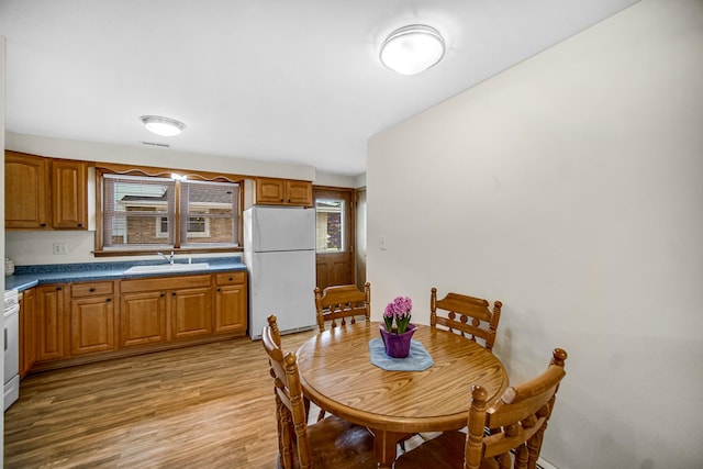 dining area featuring light wood finished floors and visible vents