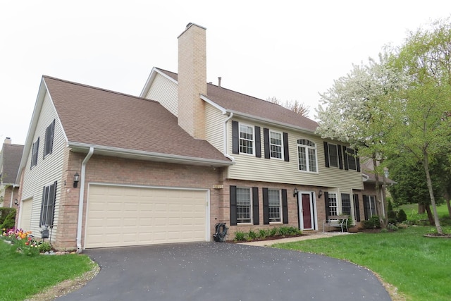 view of front of home featuring brick siding, driveway, a chimney, and a garage