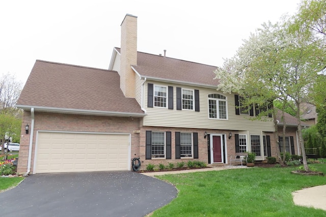 colonial home with asphalt driveway, a garage, a front lawn, and a chimney