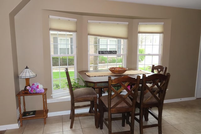 dining room featuring plenty of natural light, baseboards, and light tile patterned floors