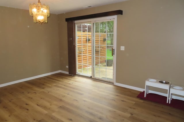 unfurnished dining area featuring wood finished floors, a chandelier, and plenty of natural light