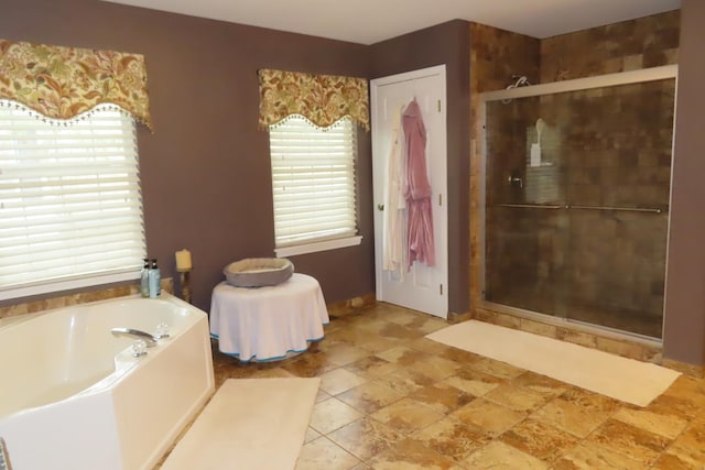 bathroom with a stall shower and a bath